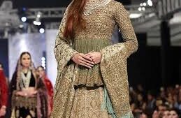 A 2025 Mughal-inspired bride wearing a richly embroidered lehenga with intricate gold zardozi work, traditional jewelry, and a regal dupatta, blending historical elegance with modern design.”