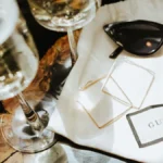 A curated display of 2025 fashion accessories including statement necklaces, smartwatches, eco-friendly bags, and minimalist sunglasses, arranged on a neutral backdrop to highlight their versatility and style."