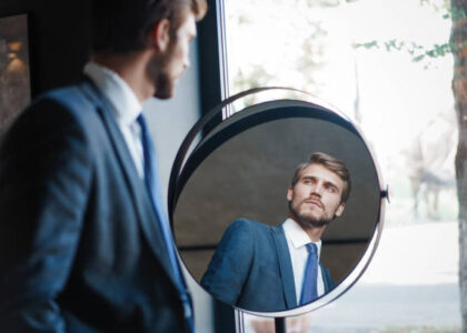 A stylish man confidently adjusting his blazer, illustrating the psychology of menswear and how clothing choices influence personal style and self-expression.