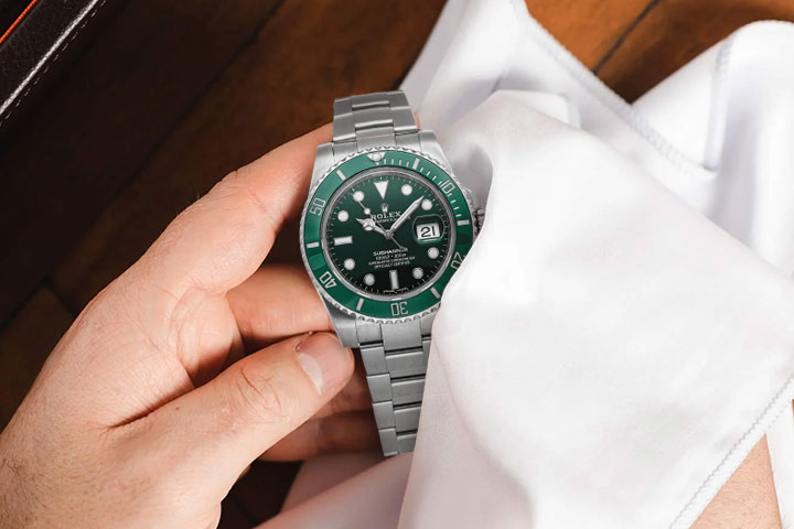 A polished luxury watch with cleaning tools beside it, demonstrating luxury watch care resources in use.