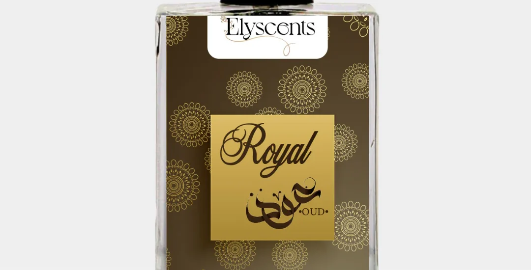 Elegant glass bottle of Royal Oud Elyscents fragrance surrounded by oud wood chips and amber, symbolizing luxury and warmth.
