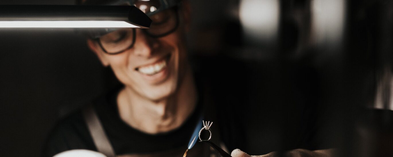 A man thoughtfully selecting a gold necklace from a curated ethical jewelry collection — a visual guide on how to choose ethical fine jewelry.