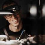 A man thoughtfully selecting a gold necklace from a curated ethical jewelry collection — a visual guide on how to choose ethical fine jewelry.