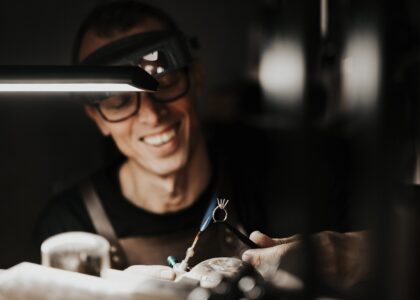A man thoughtfully selecting a gold necklace from a curated ethical jewelry collection — a visual guide on how to choose ethical fine jewelry.