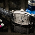 “Man wearing a Caliber 20 watch with a navy blazer and dark jeans”