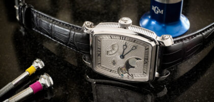 “Man wearing a Caliber 20 watch with a navy blazer and dark jeans”