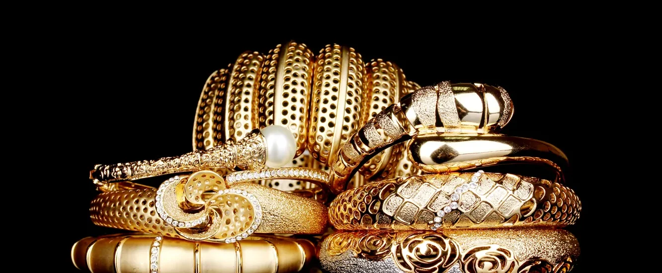 Showcase of NYC luxury jewelry inside an upscale Manhattan boutique, featuring gold and diamond pieces under soft lighting.