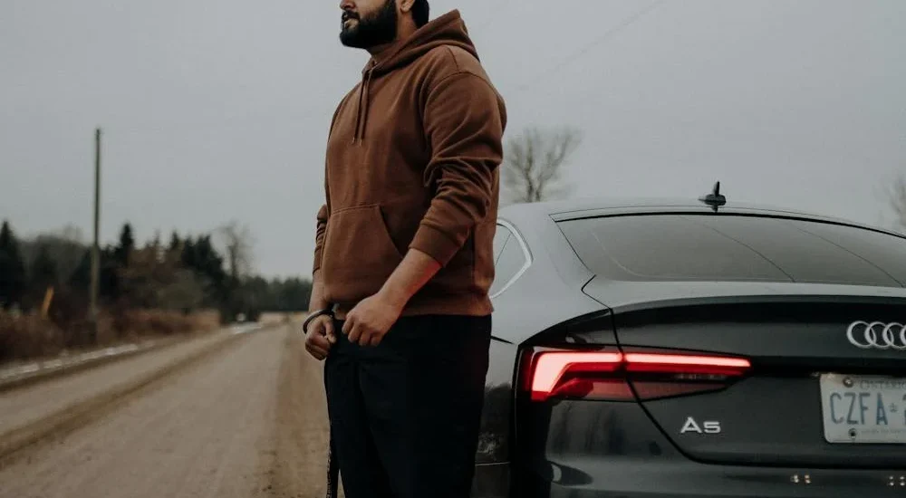 A stylish young man wearing Levi’s men’s jeans and white sneakers, standing confidently on a city street with casual urban flair – showcasing the comfort and timeless design of Men’s Jeans Levi’s.
