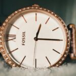 Elegant US brand watches for ladies displayed on a marble table with gold and rose gold finishes, styled with delicate jewelry.