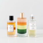 A flat lay of perfume bottles, lotion, and a silk scarf with soft lighting, showing a fragrance layering routine.