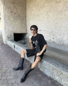 Fashionable woman wearing mini shorts and biker boots in an urban street-style outfit.