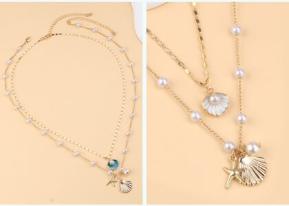 Flat lay of sea-inspired jewelry featuring shell earrings, a pearl necklace, and gold starfish charms styled on a beach towel with sunlight.