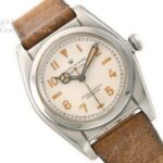 Vintage Rolex Oyster watch on leather strap styled with minimalist accessories for 2025 old-money aesthetic.
