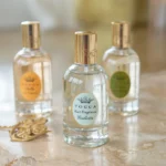 the Hair Perfume Trend by spraying a floral hair mist over styled waves in front of a vanity mirror, showcasing 2025 beauty routine