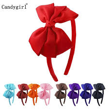 Model with satin ribbon bow in hair styled with pastel outfit, embracing the ribbon bow fashion trend.