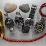 Flat-lay of trending summer 2025 watches: green dial, titanium, and retro design on white linen”
