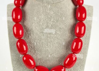 "Model wearing a bold chunky beaded necklace with a white top and minimal makeup, showcasing a high-street-meets-runway style"