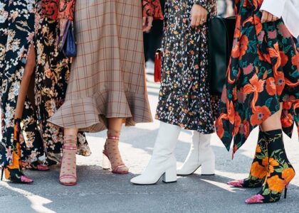 Model walking during Copenhagen Fashion Week's street style showcase wearing bold sneakers and layered fall outfit.