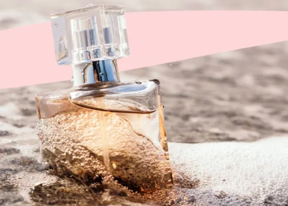 12 perfumes that smell like a beach vacation lined up on sandy beach towel